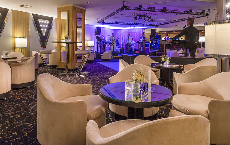 Elegant bar area with live band, atmospheric lighting and comfortable seating for guests.