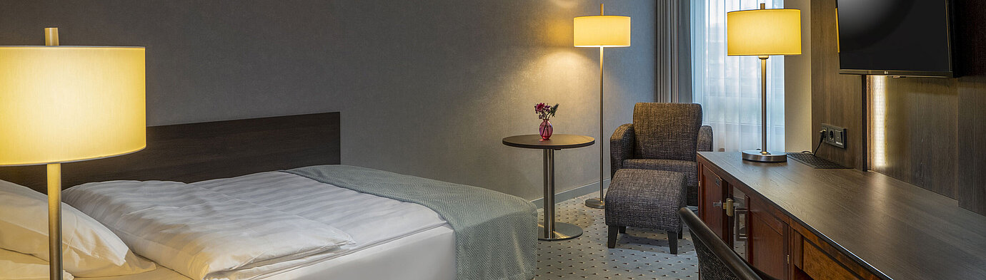 Classic Single room Modernly furnished Classic room with desk, TV, seating area, and comfortable bed at Maritim Hotel Bremen.