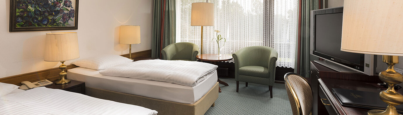 Classic room Double room with two beds, armchairs, desk and balcony at Maritim Hotel Bad Salzuflen