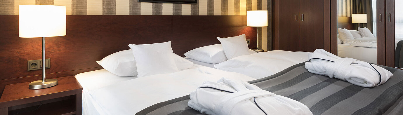 Modern double room with cozy bed, bathrobes, and stylish interior at Maritim Hotel Königswinter.