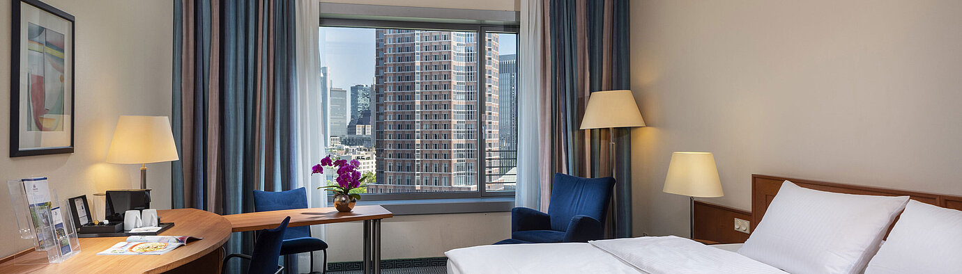 Superior Skyline room Superior room at Maritim Hotel Frankfurt with a double bed, desk, and view of the Frankfurt skyline.