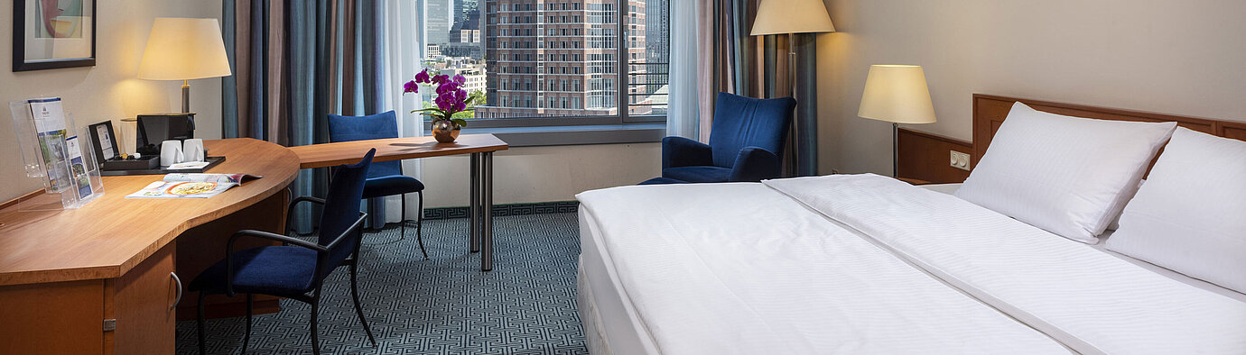 Superior Skyline room Superior room at Maritim Hotel Frankfurt with a double bed, desk, and view of the Frankfurt skyline.
