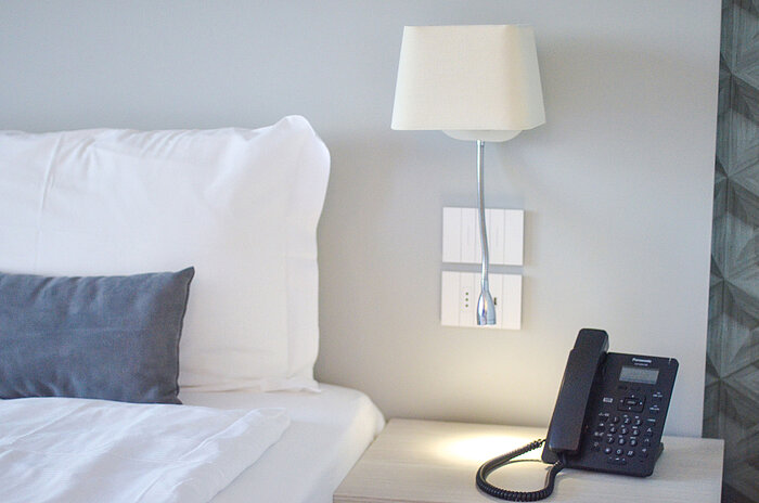 Standard room Close-up of nightstand at Maritim Resort Calabria with phone and LED reading lamp