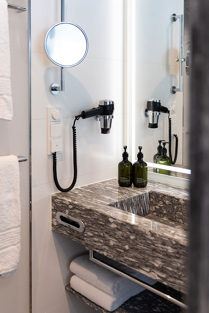 Modern vanity with mirror, hairdryer and toiletries at Maritim Hotel Amsterdam