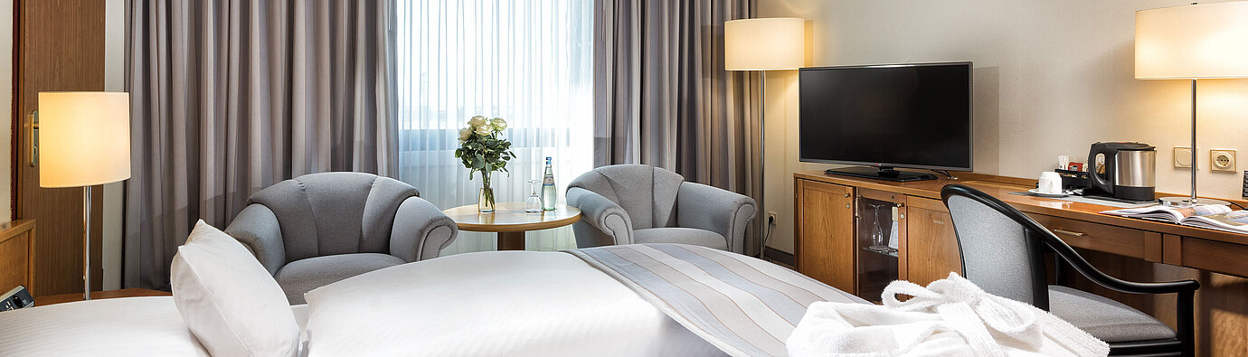 Superior room  Superior double room with stylish furnishings, cozy seating area, water bottles and a bathrobe on the bed.