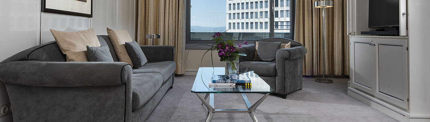 Executive Suite Spacious Executive Suite at Maritim Hotel Frankfurt with elegant decor, cozy seating area, and panoramic window.