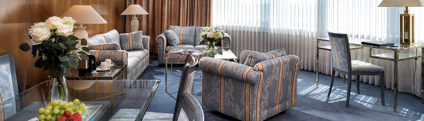 Master suite  Elegant Master Suite at Maritim Hotel Hannover with classic design, stylish seating, and bright panoramic windows.