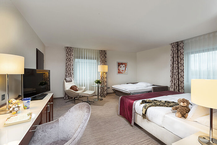 Comfort family room at Maritim Hotel Bonn with modern furniture, sofa bed, and stylish decor for a relaxing stay.