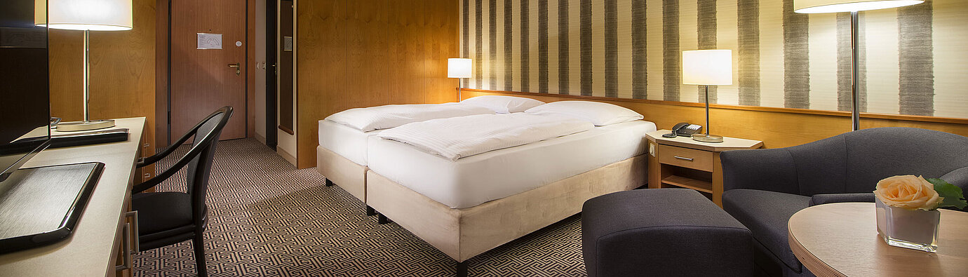 Classic room Bright double room with soft lighting and cosy sitting area at Maritim Hotel Stuttgart