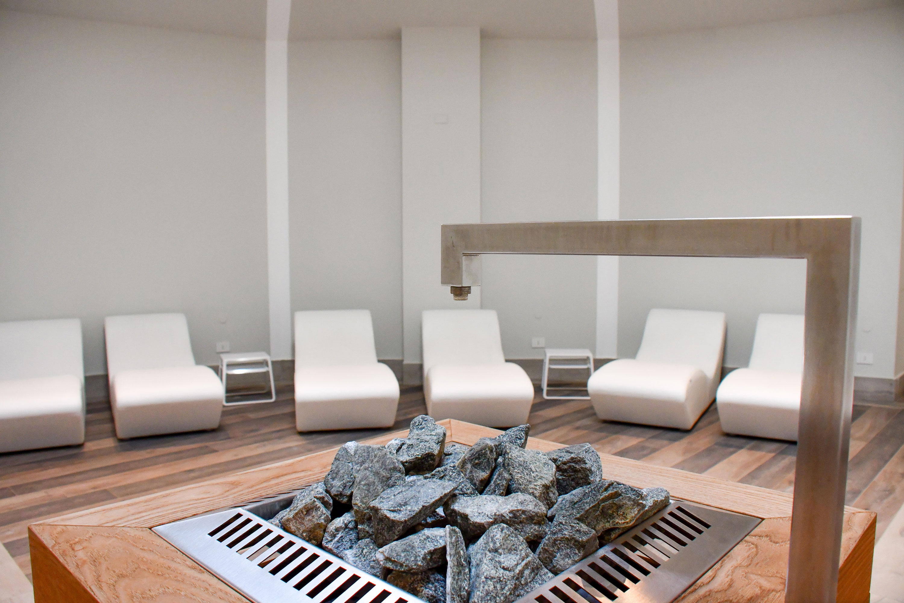 Relaxation room with sauna heater Modern relaxation room at Maritim Resort Calabria with loungers and central sauna heater for peaceful breaks.
